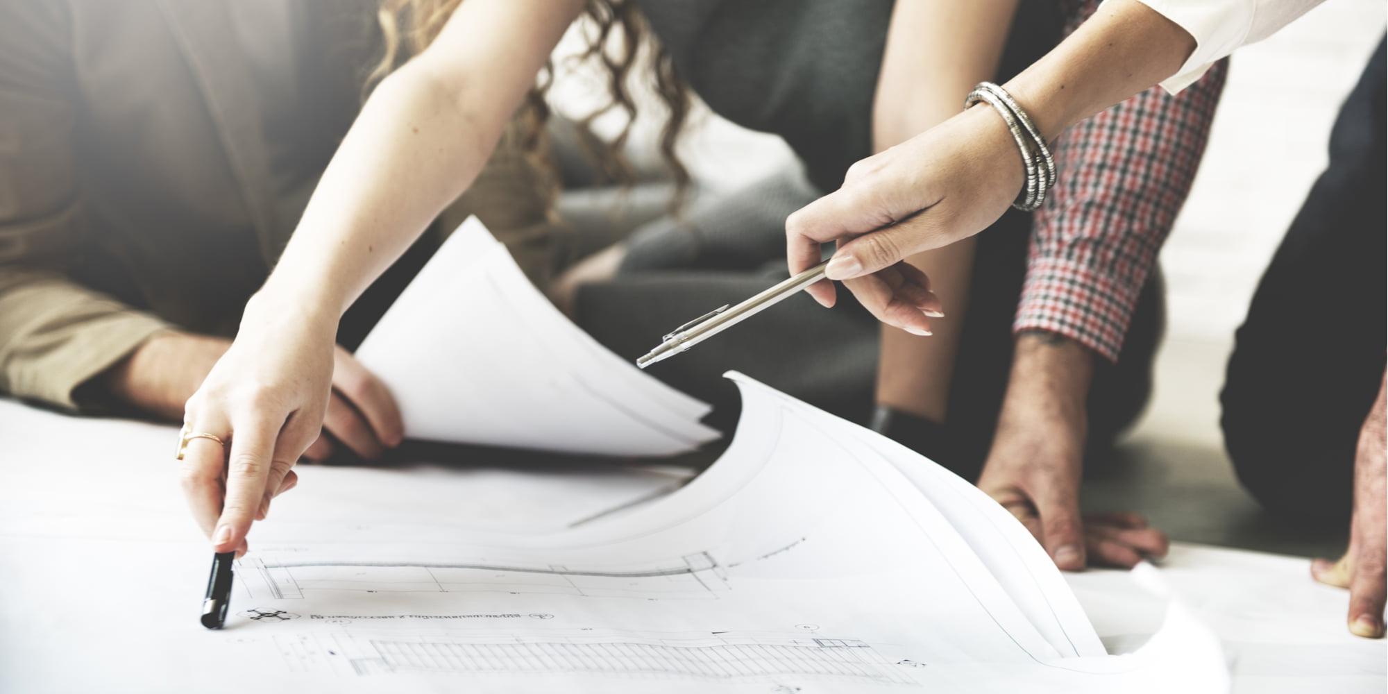 Multiple people planning on paper. 